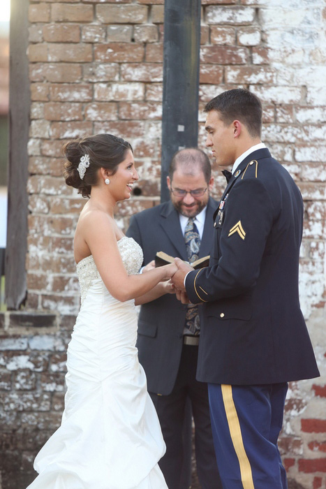 groom putting ring on bride's finger