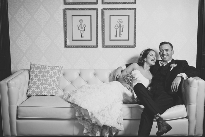 bride and groom laughing on the couch