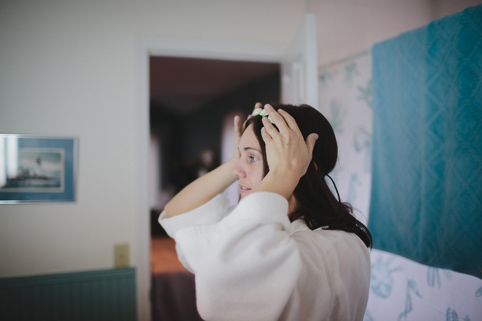 bride putting on her head piece