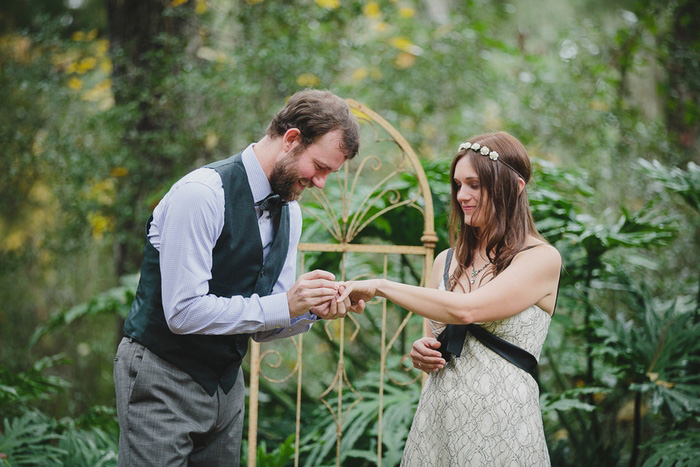 groom putting ring on bride's finger