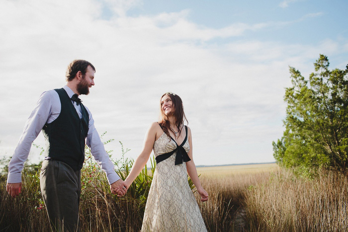 bride and groom walking in field