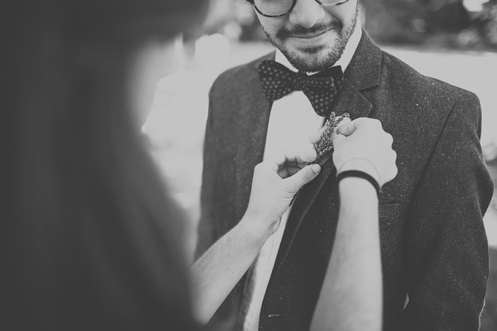 groomsman pining on boutonniere