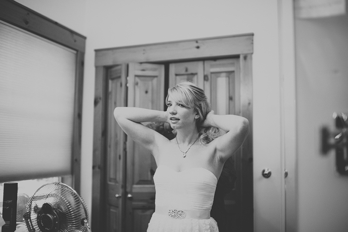 bride putting on necklace