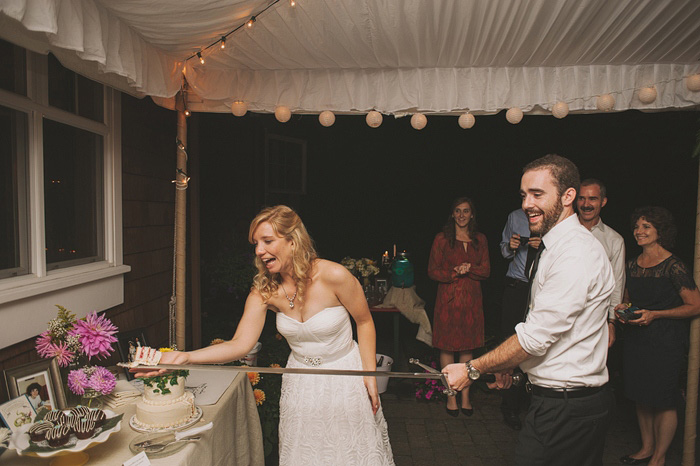 groom cutting cake with a sword