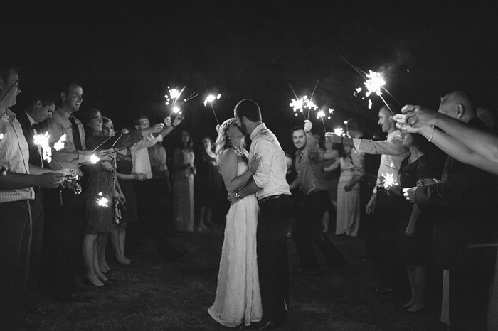 bride and groom kissing under sparkler send-off