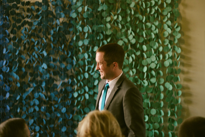 groom in front of ombre ceremony backdrop