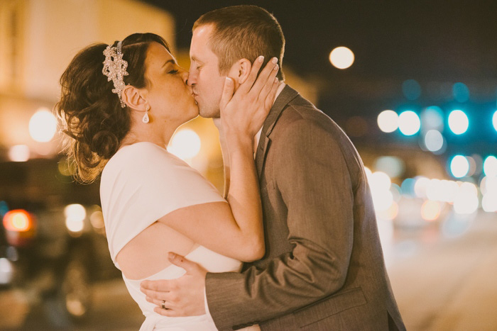 bride and groom kissing in the street