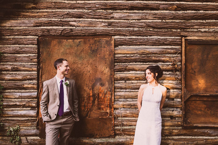 wedding portrait in front of log cabin