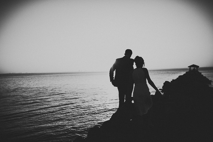 Bride and groom sunset stroll by the water