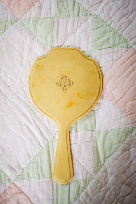 vintage hand mirror on quilt