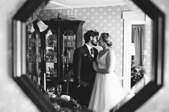 bride and groom kissing reflection
