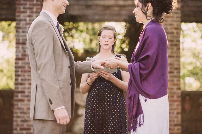 bride putting ring on groom's finger