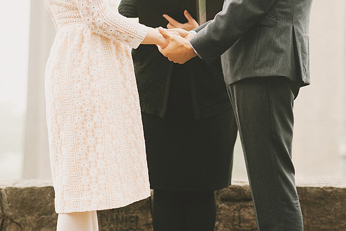 bride and groom holding hands at ceremony