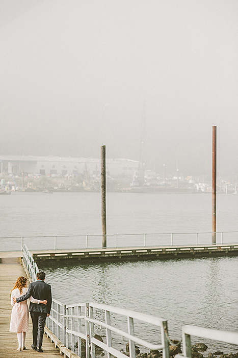 bride and groom walking down pier