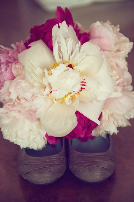 white and pink peony bouquet on wedding shoes