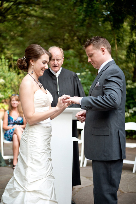 bride putting ring on groom's finger