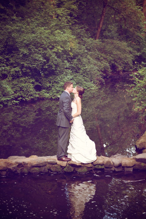 bride and groom kissing in the woods