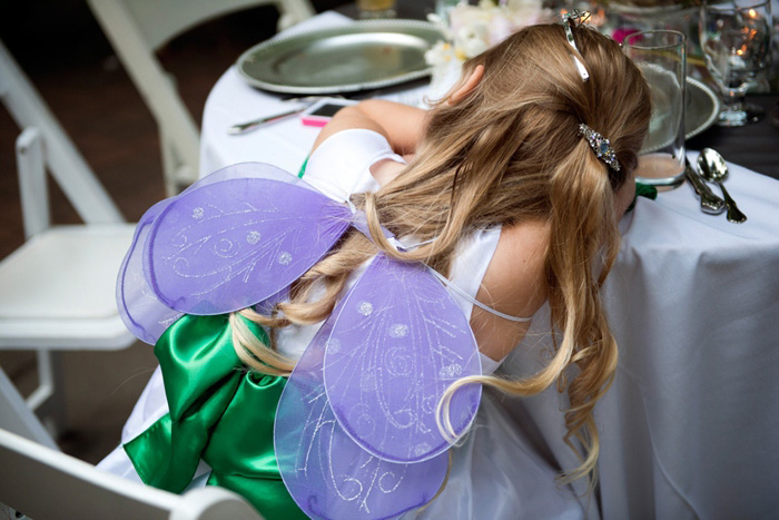 flower girl with wings asleep at table