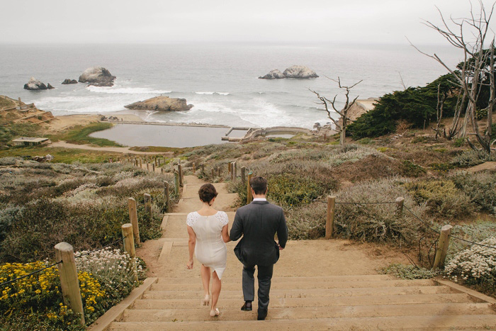 bride and groom walking down stairs to the ocean