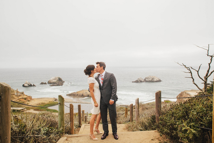 bride and groom kissing by the ocean