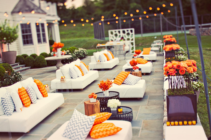 white lounge sofas with orange cushions