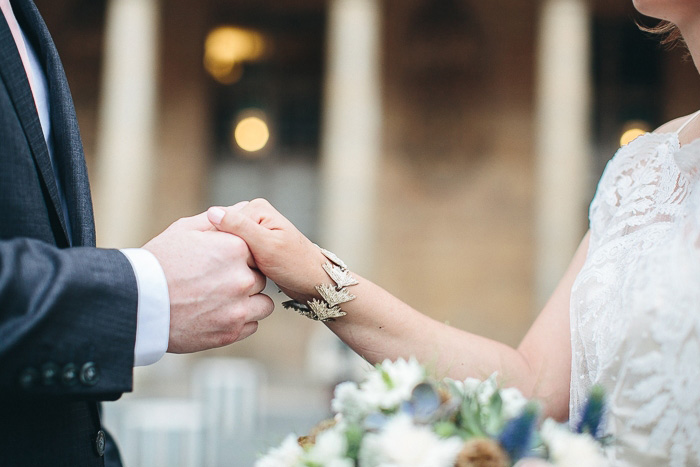 bride and groom holding hands while exchanging vows