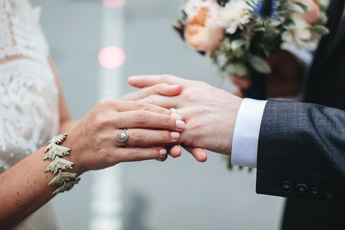 bride placing ring on groom's finger