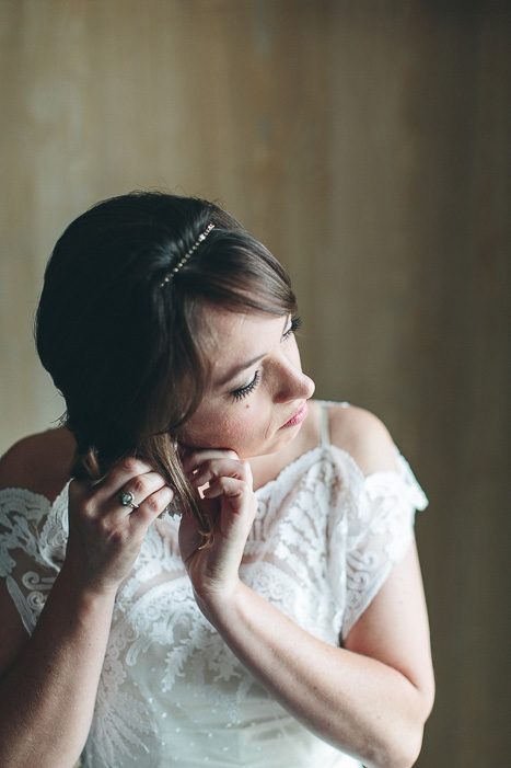 bride putting on her earrings