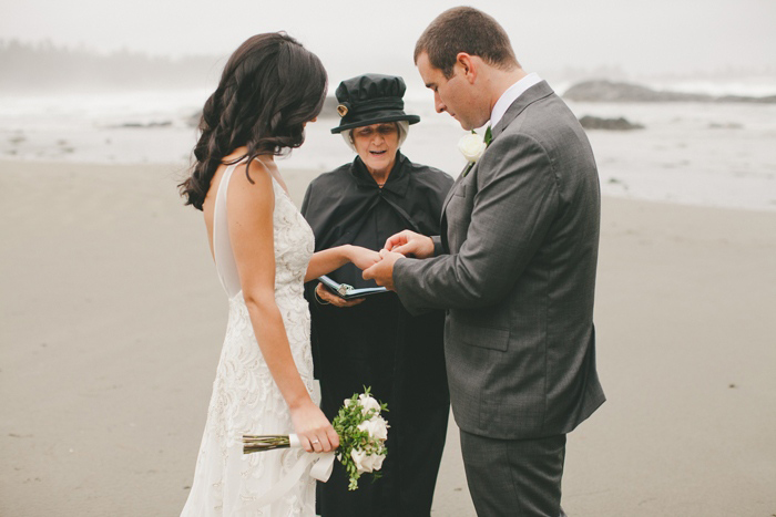 bride and groom exchanging rings on the beach