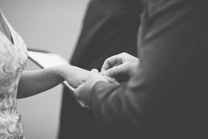 groom placing ring on bride's finger