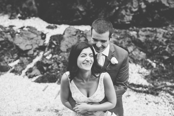 bride and groom laughing on the beach