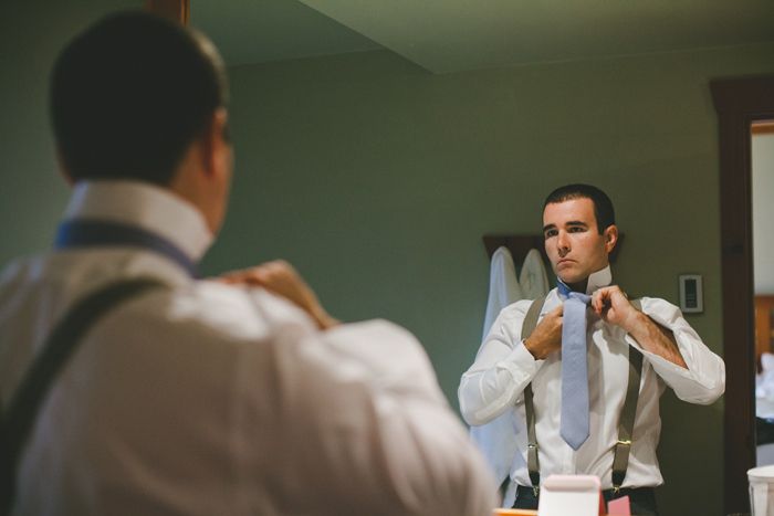 groom putting on his tie