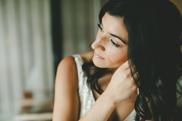 bride putting on her earrings