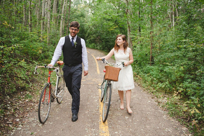 bride and groom walking down the road with bikes