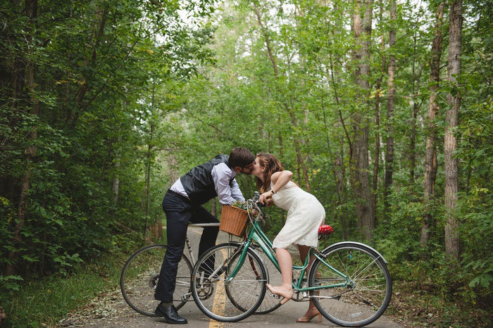 bride and groom kissing on bikes