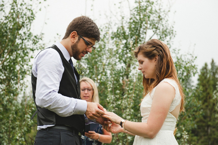 groom putting ring on bride's finger