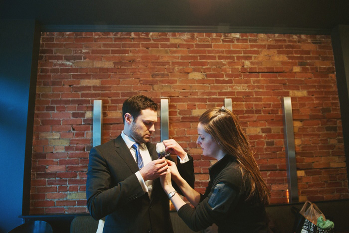 groom pinning on boutonniere