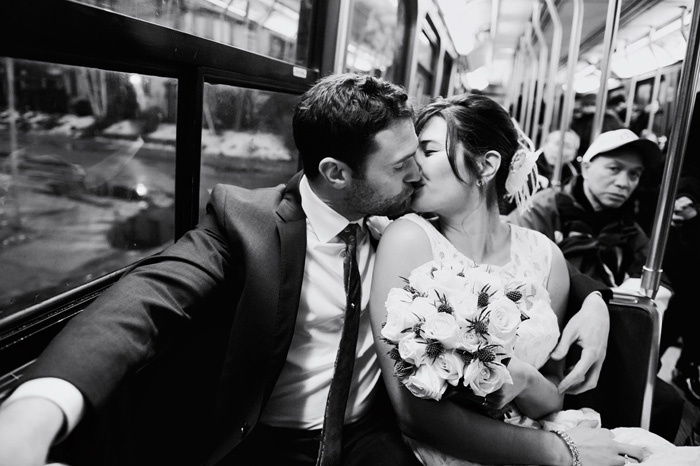 bride and groom kissing on the streetcar