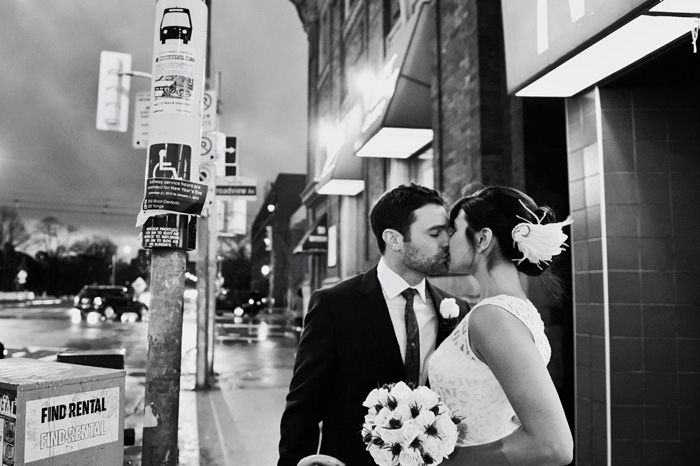 bride and groom kissing on the street at night