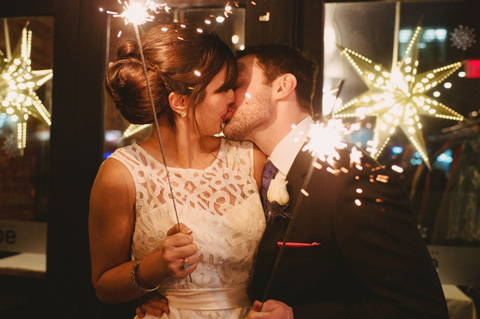 bride and groom kissing with sparklers