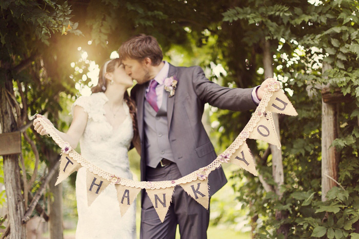 bride and groom with thank you bunting