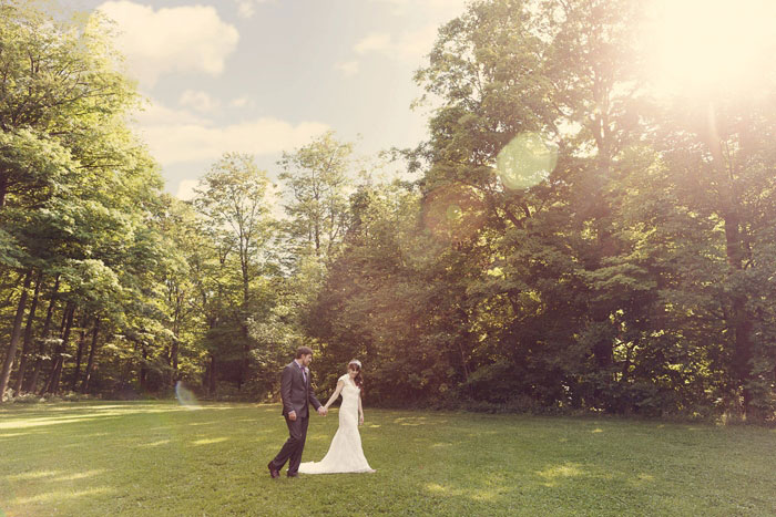 bride and groom walking across field