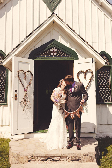 bride and groom kissing in front of church