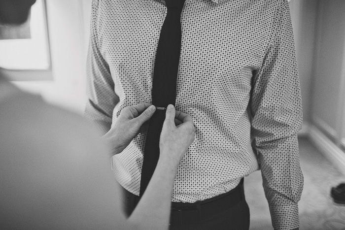 bride clipping groom's tie