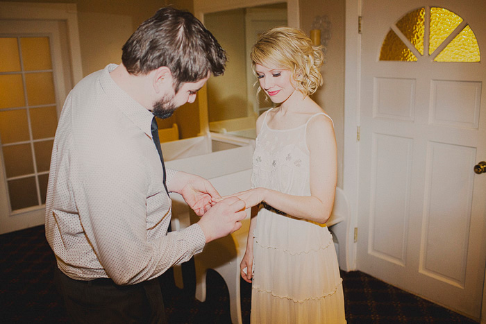 groom placing ring on bride's finger