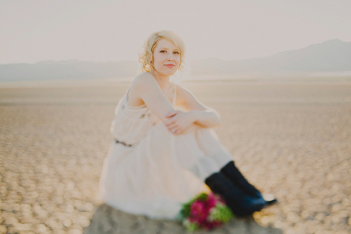 bride sitting in dry lake bed