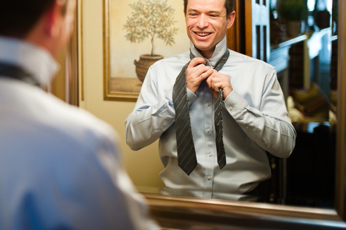 groom putting on tie