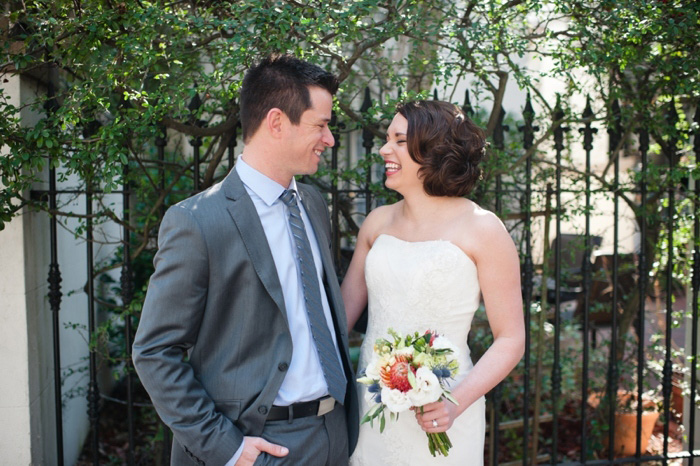 bride and groom in front of wrought iron fence