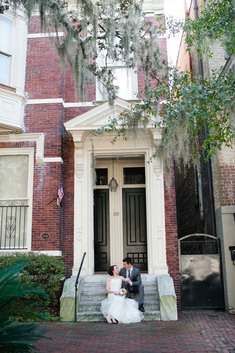 bride and groom on steps of historic house