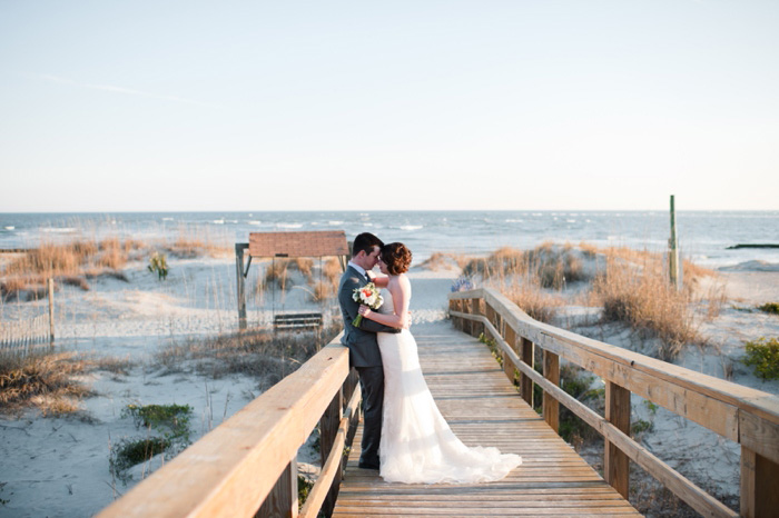 bride and groom kissing on the boardwalk